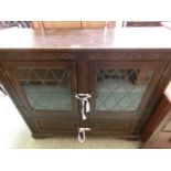 A reproduction oak cabinet having a pair of glazed doors above two cupboard doors