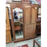 An early 20th century mahogany inlaid compactum having a bevel glass mirrored door