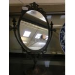 A gilt metal oval swing mirror