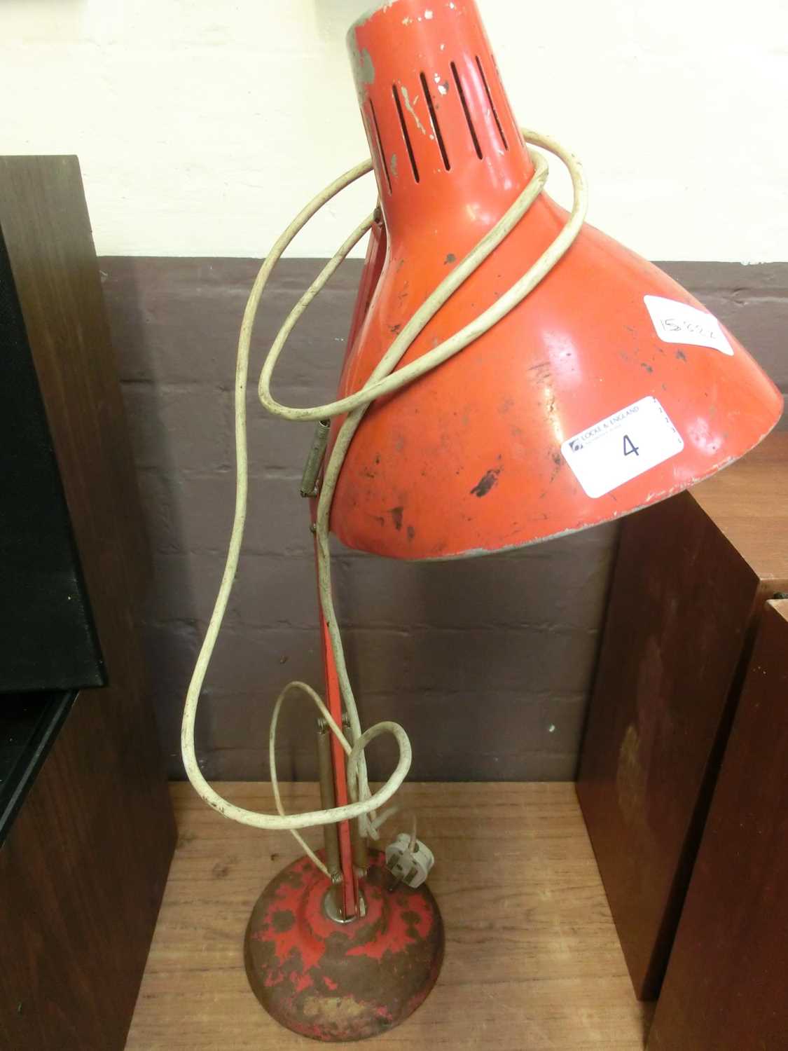 A red angle poise style lamp