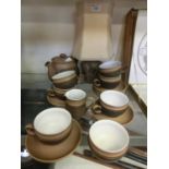 A brown stoneware part tea set comprising of cups, saucers, teapot, cream jug, etc, together with an