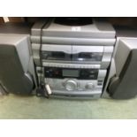 A Bush five CD music centre with tuner unit and cassette deck with a pair of speakers