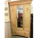 An early 20th century satinwood wardrobe having a bevel glass centre door with drawer to base