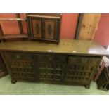 A Spanish oak dresser base having three drawers above panelled doors