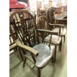 A pair of open arm wheel back chairs together with a wheel back dining chair