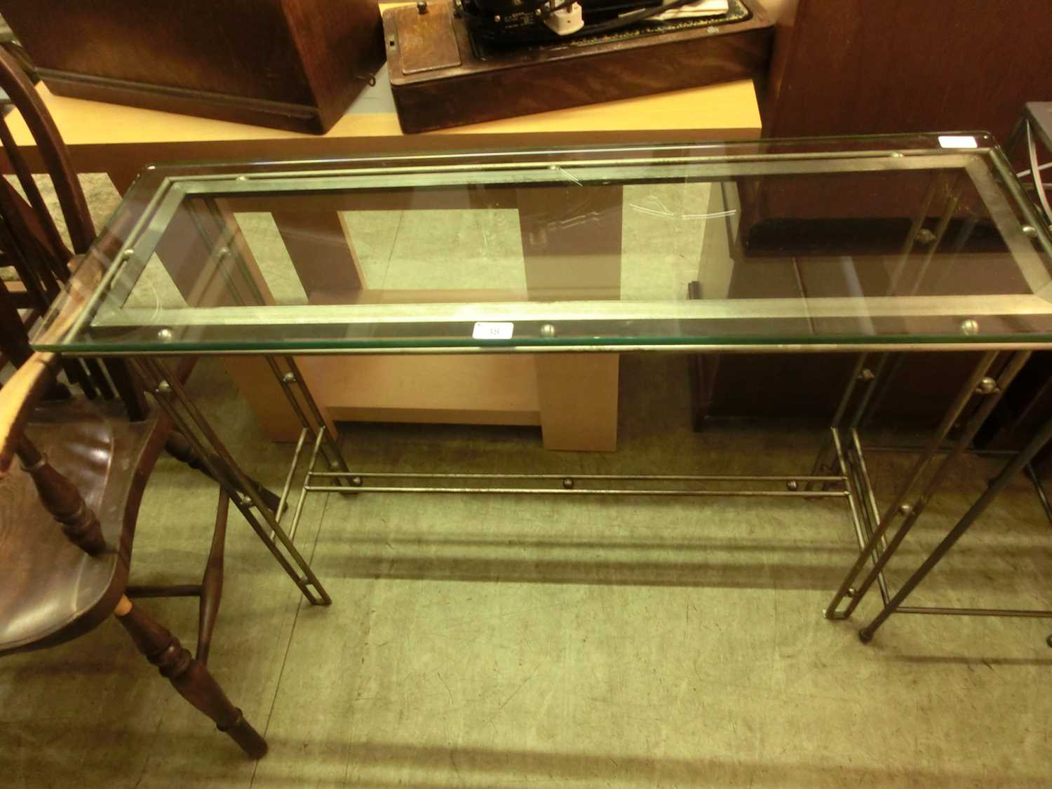 A modern plate glass console table supported on metal base