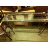 A modern plate glass console table supported on metal base