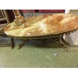 A gilt metal and brown onyx oval coffee table