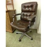 A chrome and leather button upholstered office chair with five star base