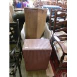 A cream painted Lloyd Loom chair together with a gold painted Lloyd Loom ottoman and another pink