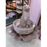 A scalloped bird bath top along with a garden planter and a garden ornament in the form of an otter