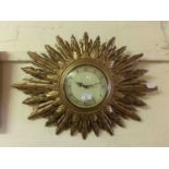 A sunburst wall clock by Smiths