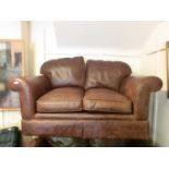 A brown leather two seater sofa