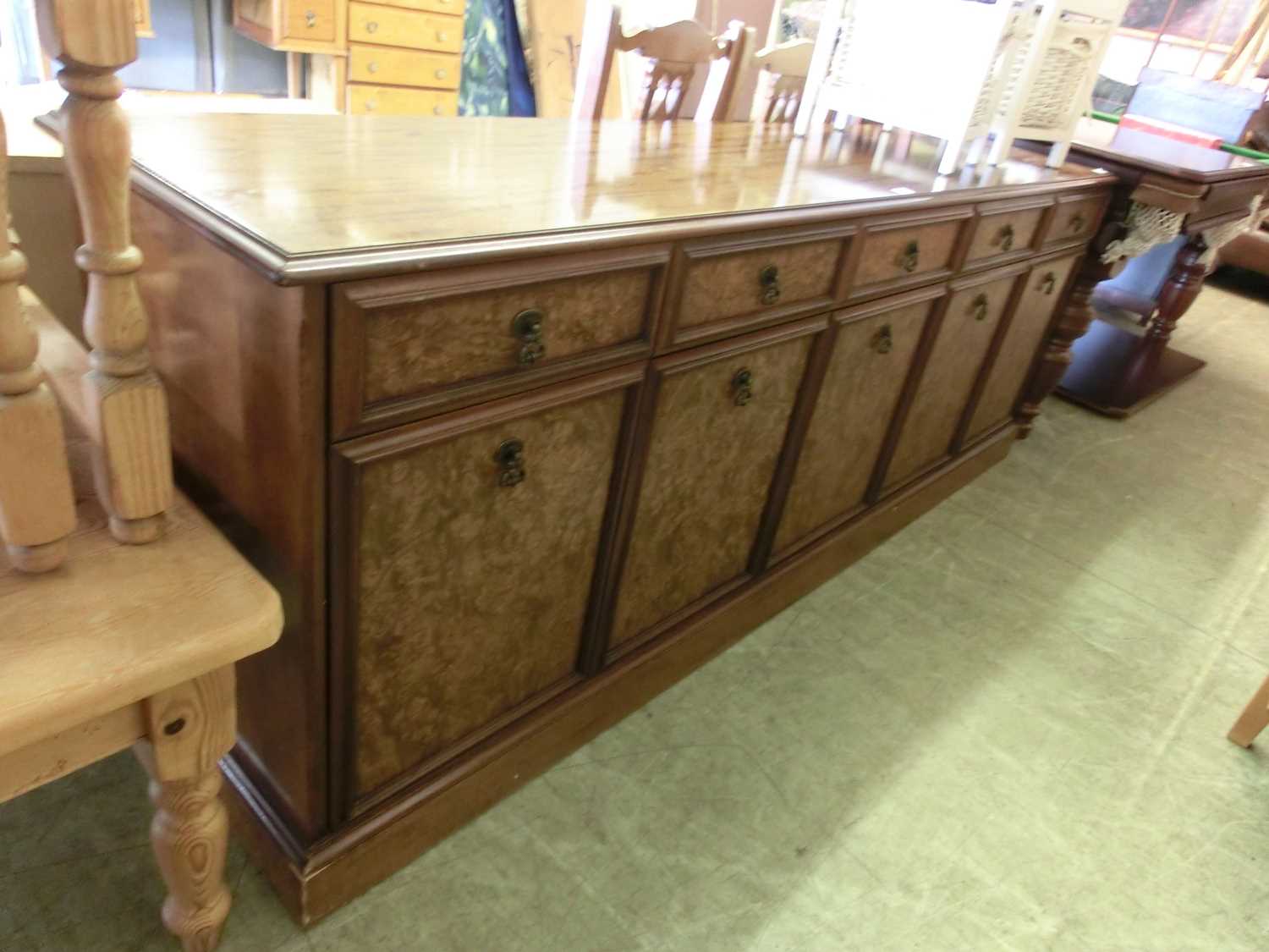 A modern bur walnut and walnut dresser base, three drawers over cupboard doors on plinth base