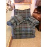 An armchair upholstered in a blue checked fabric with scatter cushion