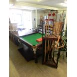 A quarter sized snooker table with dining table leaves to top along with snooker cue racks with
