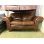 A brown leather two seater sofa