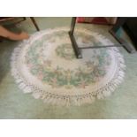 A circular cream floral decorated wool rug