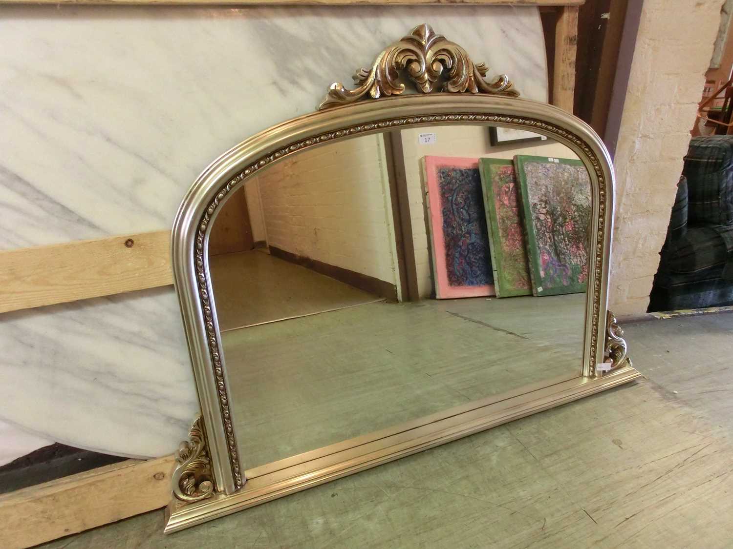 A silver framed over mantle mirror