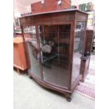 A mahogany bow fronted glazed cabinet with ball and claw feet