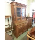 A late 19th century oak bookcase cabinet having a pair of glazed doors to top, the base having two