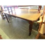 An early 20th century walnut wind-out table with one extra leaf