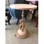 A simulated marble topped occasional table with gilt metal stem and cherub design