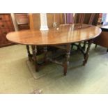 An 18th century style oak wake/dining table, the oval top with drop leaves supported on two