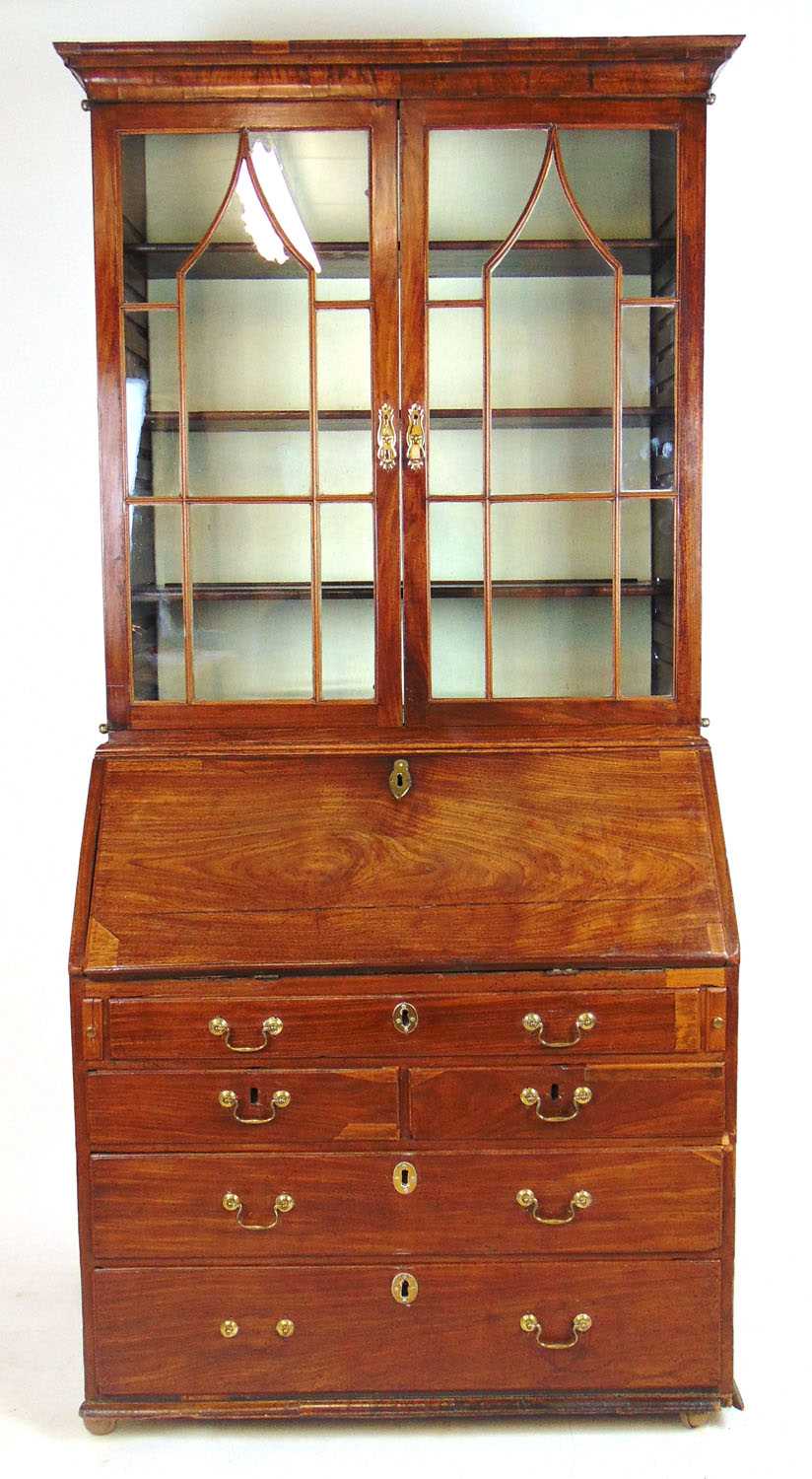 A mid 18th century walnut bureau bookcase, the cavetto cornice over two astragal glazed doors