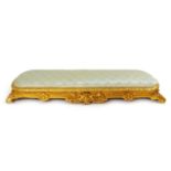 A 19th century gilt wood foot stool, the pad seat upholstered in a light blue silk, h. 14 cm, w. 109