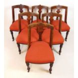 A set of six late 19th century carved oak framed dining chairs with red patterned upholstery on