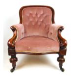 A Victorian mahogany nursing chair upholstered in a pink button back fabric, the moulded frame