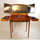 An early 20th century satinwood dressing table with machine turned and blue glass silver