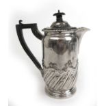 A late Victorian silver hot water pot with embossed decoration. Hallmarked for London 1900, maker