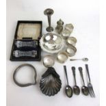 An assortment of silver items to include napkin rings, knife rests, pepper pot, forks etc. Various