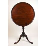 A mid 18th century mahogany tripod table, The one piece dish tilt top over the turned column and