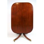 An early 19th century mahogany breakfast table, the rectangular tilt top on turned column and four