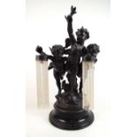 An early 20th century French spelter lamp in the form of three cupids holding lights on a turned and