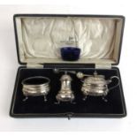 A cased George V silver three piece cruet set. Hallmarked for Birmingham 1930, makers mark for