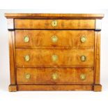 An early 19th century French Empire possibly pear wood chest of four long drawers, the drawers