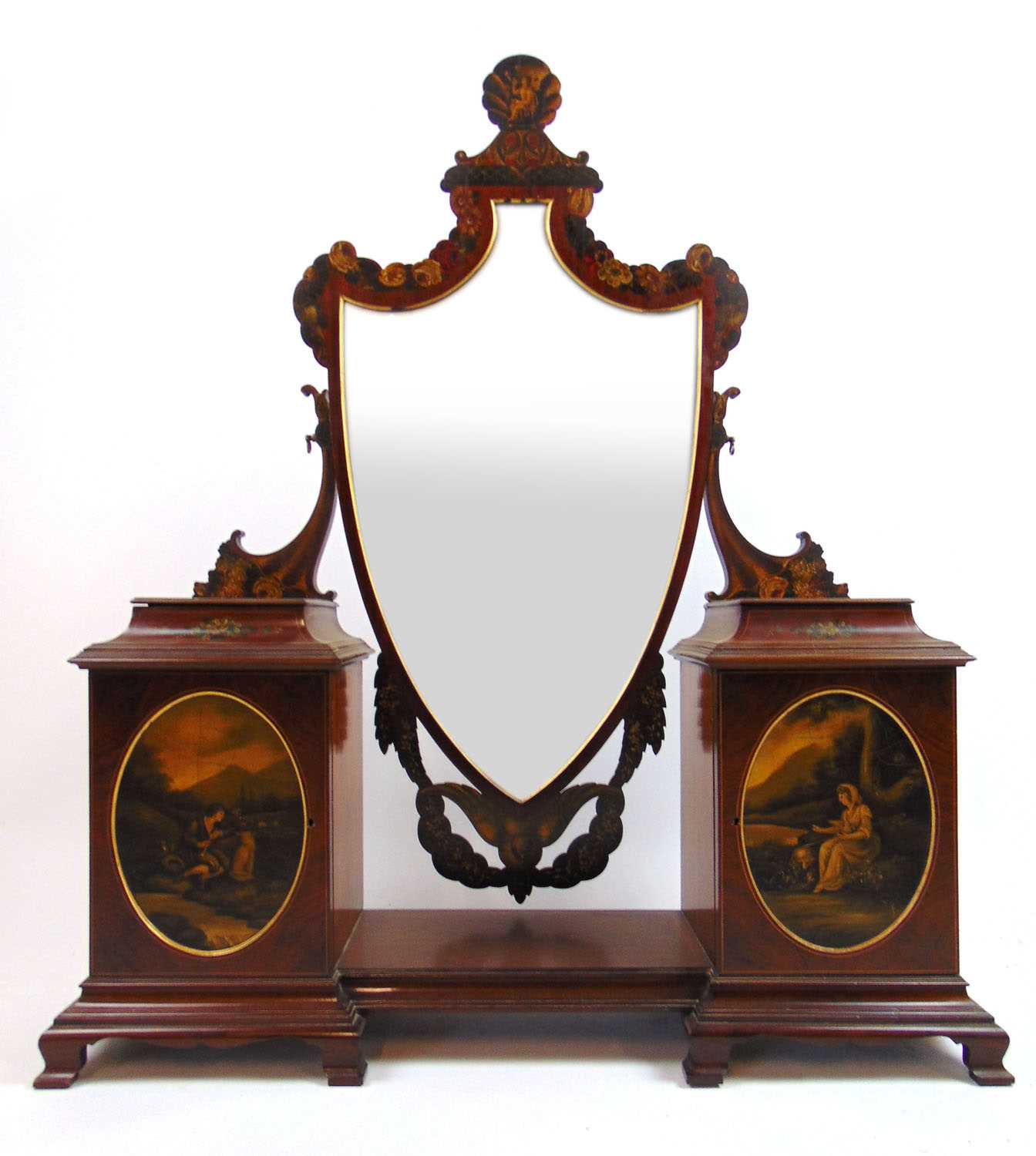 An Edwardian mahogany and painted toilet mirror, the shield plate surrounded by floral and swag