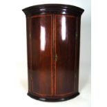 A Georgian mahogany and rosewood banded bow front corner cupboard, h. 103 cm, w. 72 cmSome banding