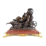 A 19th centaury bronze figure of a putto reclining on a wheelbarrow, signed L Gregoire (1840-1890)