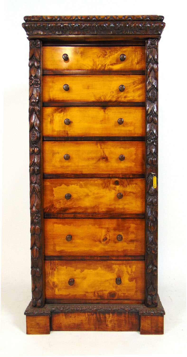 A 19th century style mahogany and birch wellington chest, the carved edged top over seven drawers on