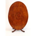 An Edwardian burr walnut oval table top on an early 19th century mahogany base with four reeded