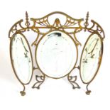 An art nouveau brass framed triple vanity mirror, the three beveled oval plates with etched