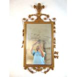 An early 20th century giltwood mirror with fleur de lys to top over the beveled plate and the