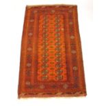A handwoven Afghan rug, the multi line border enclosing an orange ground field with two rows of