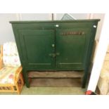 A 19th century pine cupboard painted green and missing base