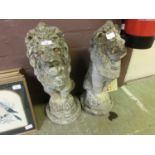A pair of composite stone garden ornaments in the form of seated lions with funny eyes